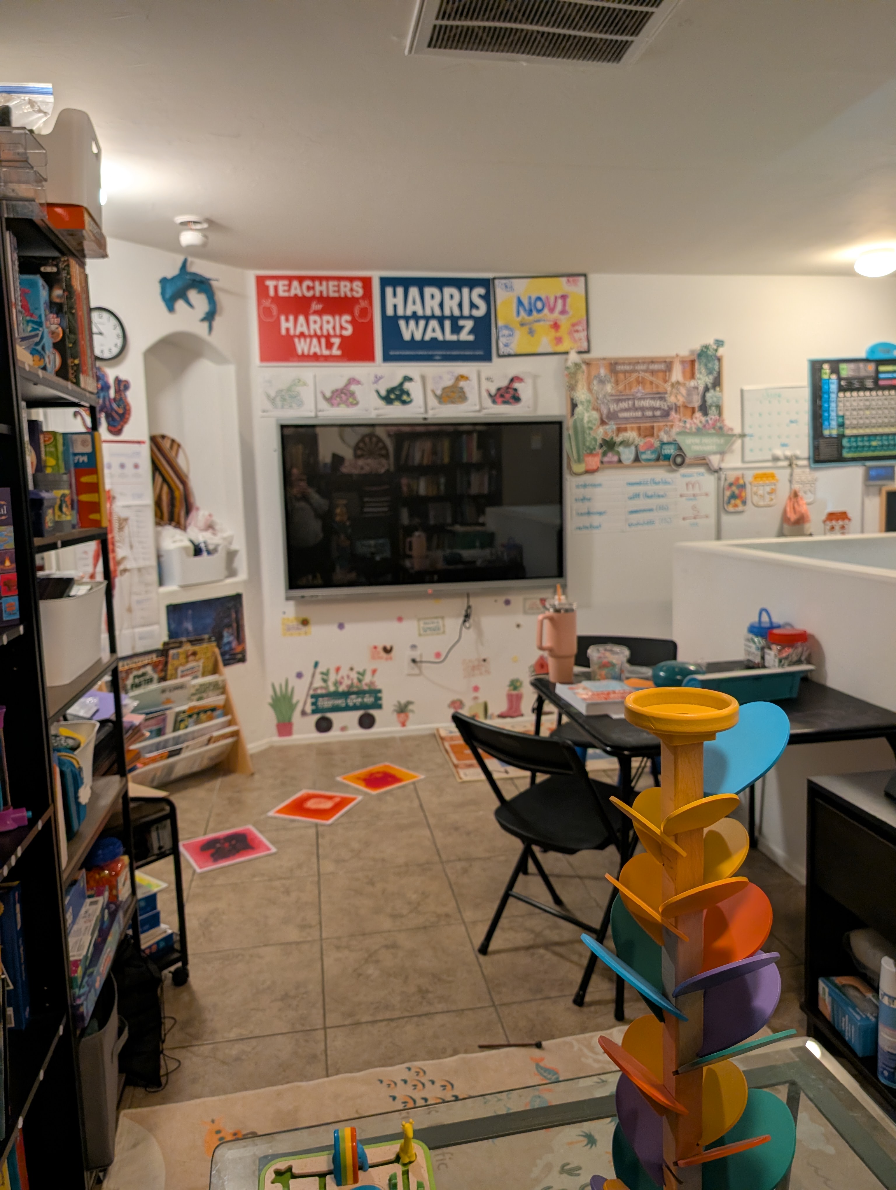 Our classroom TV wall with dinosaur artwork, a periodic table, and homemade decorations