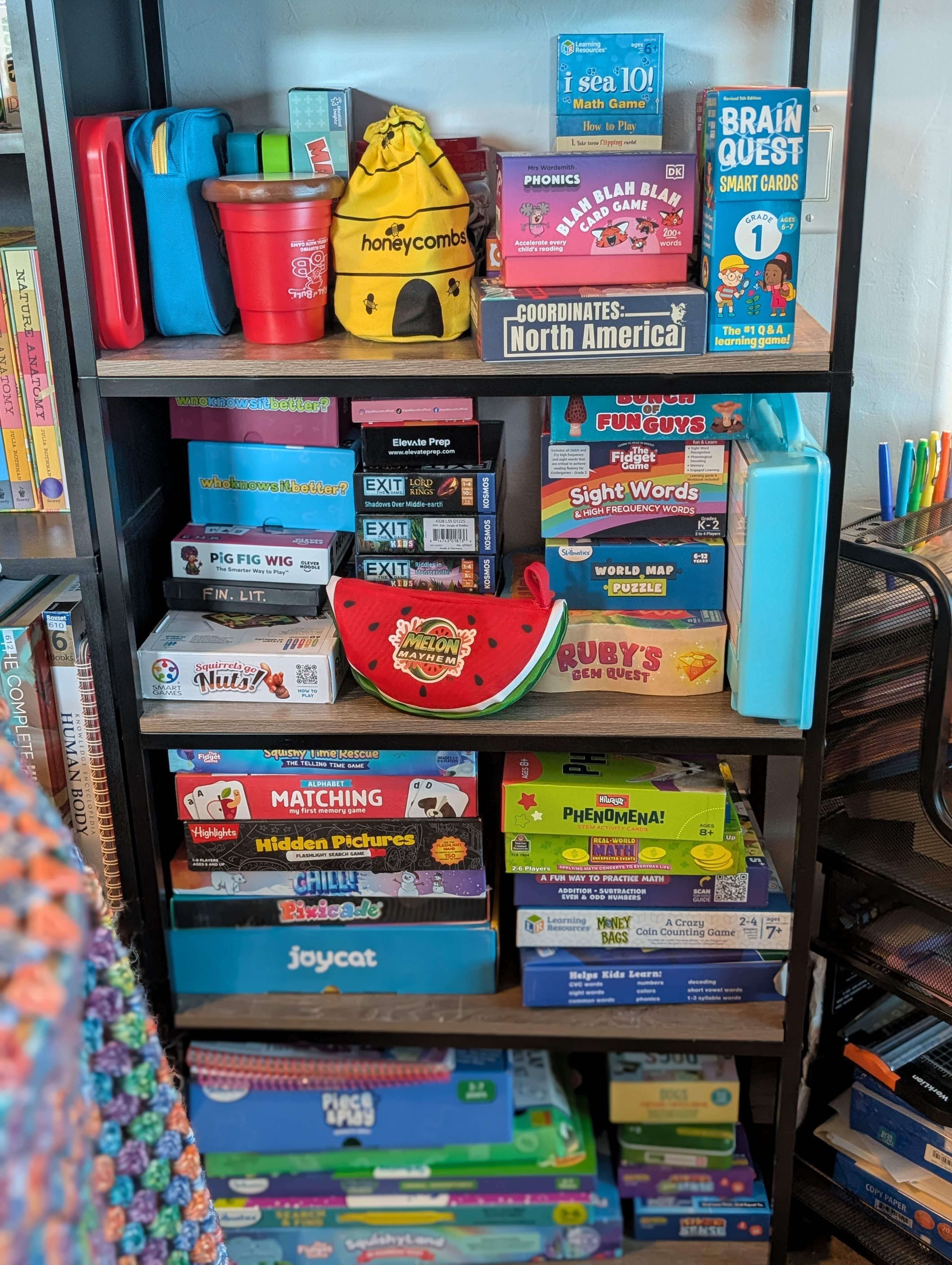 Shelves of learning games and workbooks, including Brain Quest, phonics cards, and math games